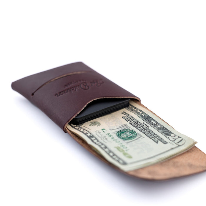 Brown leather wallet with a dollar bill on a white background