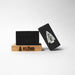 Black soap bar and packaging with 'KLENR' branding on a white background