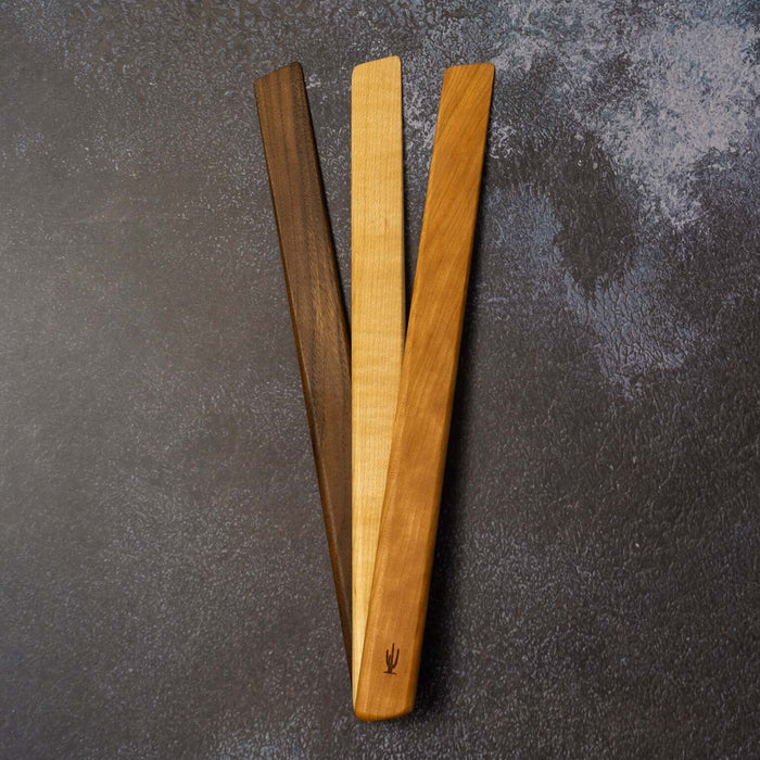 Three wooden tools on a textured gray surface