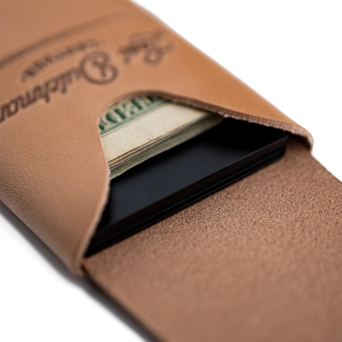 Close-up of a brown leather wallet with money and cards inside, on a white background.