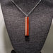 Necklace with a wooden pendant on a textured surface