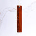 Wooden pendant with embedded material on a white marble background