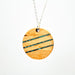 Wooden pendant necklace with blue accents on a white background